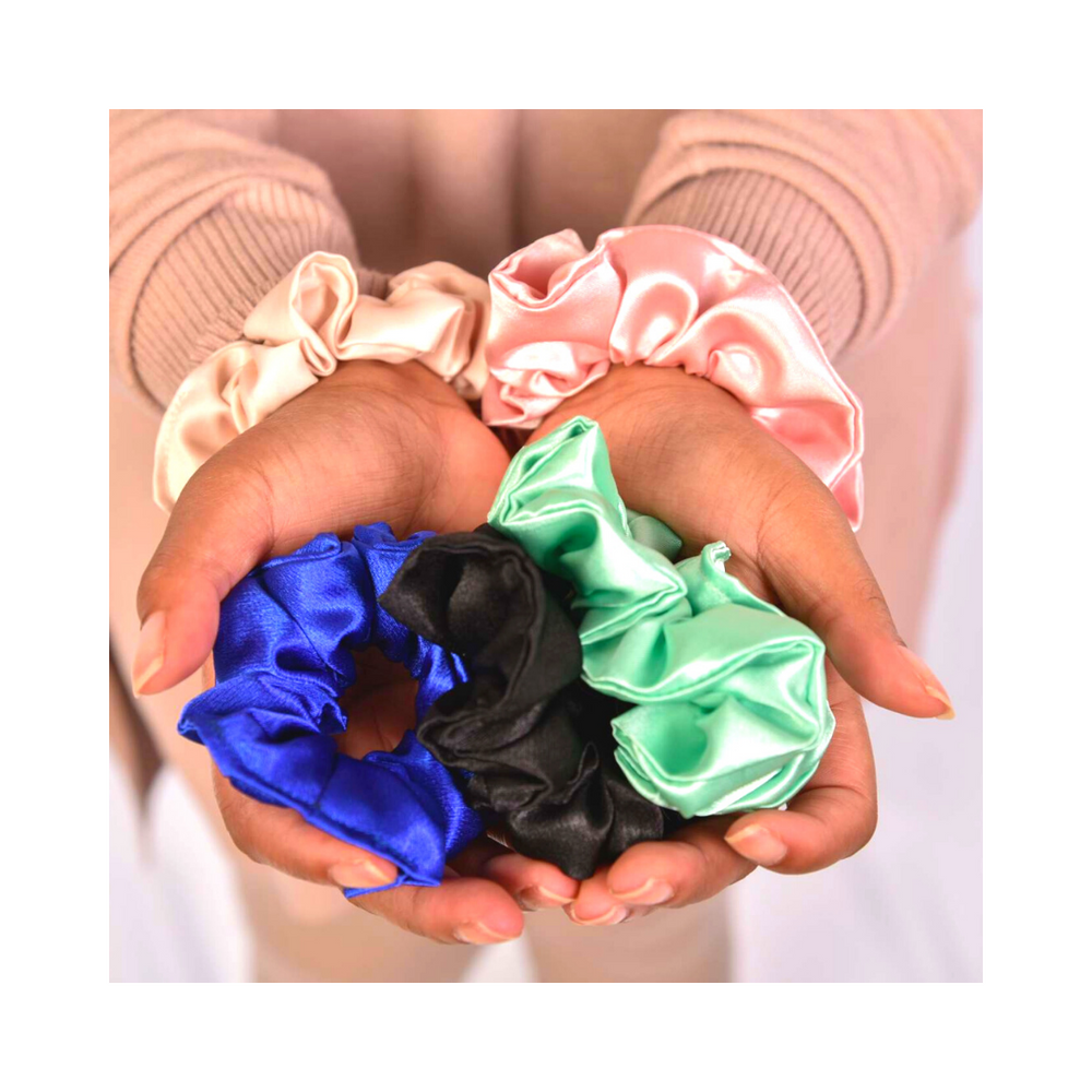 Artis Styling Satin Scrunchies being held in Cristina's hands in a variety of colors