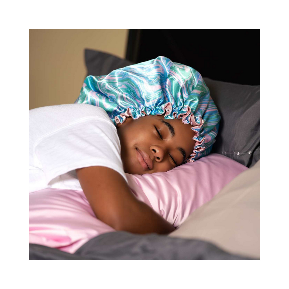 A girl wearing a Artis Styling Marbled Satin Adjustable Bonnet and Sweet Dream Satin Pillowcase